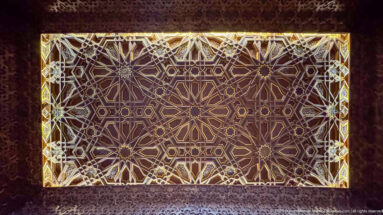Rectangular illuminated decorative panel filled with interlocking star polygons and geometric lattice patterns.