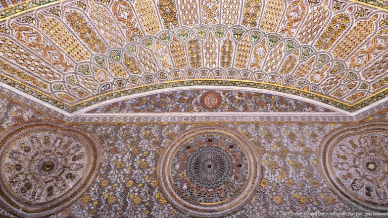 Highly ornate surface with radiating upper panels, three circular medallions, and dense floral and geometric carving.