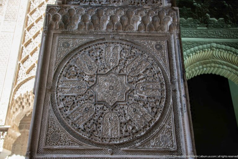 Large circular carved-stucco medallion with central star and radiating interlaced geometric and vegetal motifs.
