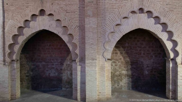 Two side-by-side scalloped arches in pale brickwork opening into dark stone recesses at the Koutoubia precinct.