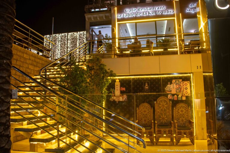 Illuminated staircase and façade of Café Restaurant El Bahja de la Koutoubia at night in Marrakech.