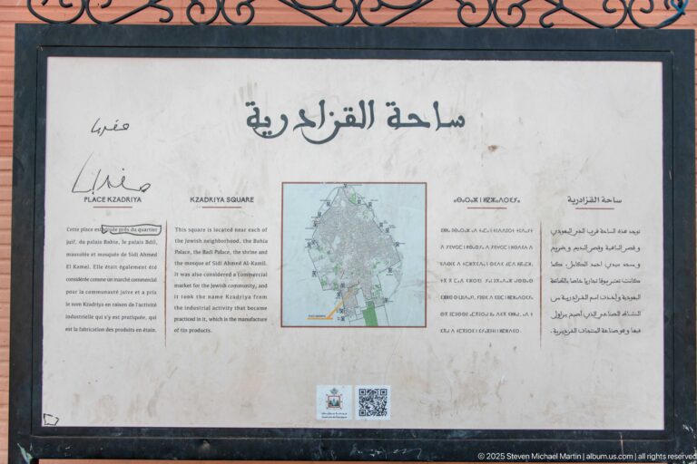 Multilingual Kzadria Square information panel with Arabic, French, English text and a small map of central Marrakech.