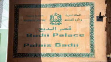 Official Badii Palace sign with Arabic, French, and English text beneath the Moroccan Ministry of Culture emblem.