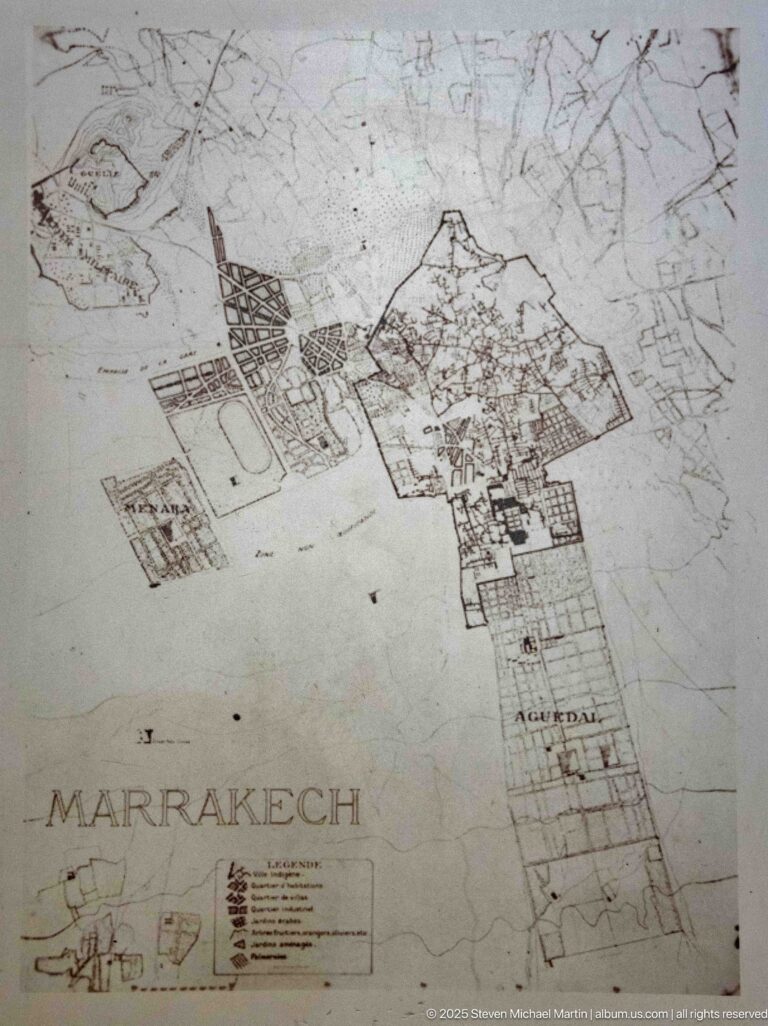Faded historic map of Marrakech showing the walled city, surrounding roads, compounds, and open land.