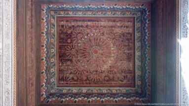 Square Bahia Palace painted ceiling panel with large radiating floral medallion and layered turquoise-red borders.