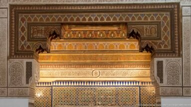 Close view of Bahia Palace fireplace hood with carved bands, painted ornament, geometric tilework and pale side panels.