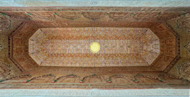 Recessed octagonal Bahia Palace ceiling with repeated painted arch motifs, layered borders and central light.