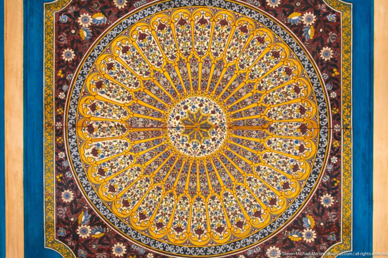 Large circular Bahia Palace painted medallion with central star and radiating multicolored floral segments.