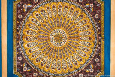 Large circular Bahia Palace painted medallion with central star and radiating multicolored floral segments.