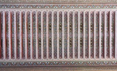 Long Bahia Palace painted timber ceiling with red ribs and repeating green, cream and geometric panels.
