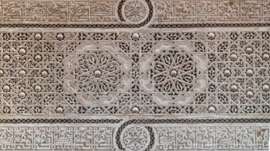 Close carved plaster panel with interlaced geometry, star forms and circular rosette medallions at Bahia Palace.