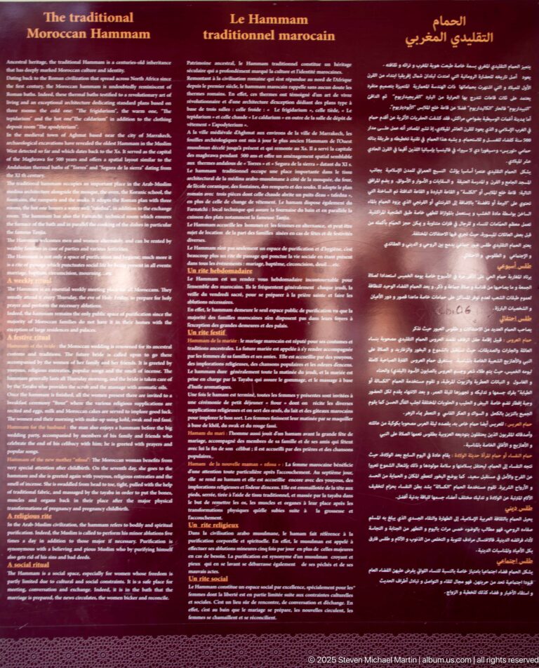 Dark red Bahia Palace interpretation panel titled about the traditional Moroccan hammam, with multilingual text including French and Arabic.