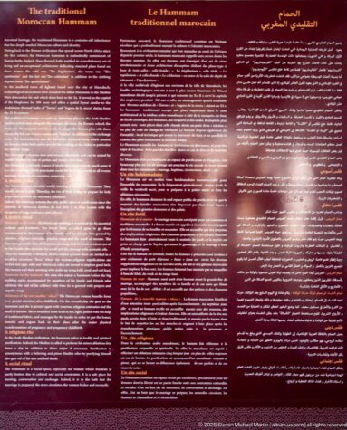 Dark red Bahia Palace interpretation panel titled about the traditional Moroccan hammam, with multilingual text including French and Arabic.