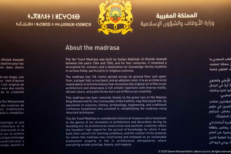 Bilingual interpretive panel titled “About the madrasa,” with Arabic and English text and the Moroccan ministry emblem above.