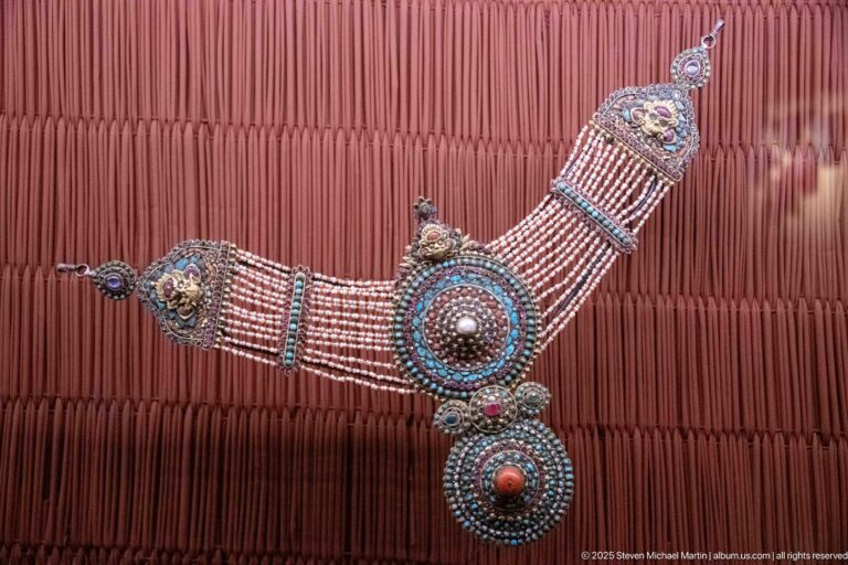 Broad beaded collar with rectangular plaques, turquoise-blue accents, and two large circular medallions.