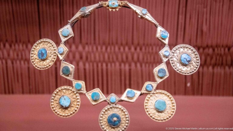 Necklace with linked blue-stone settings and five large circular pendants with turquoise-blue centers.