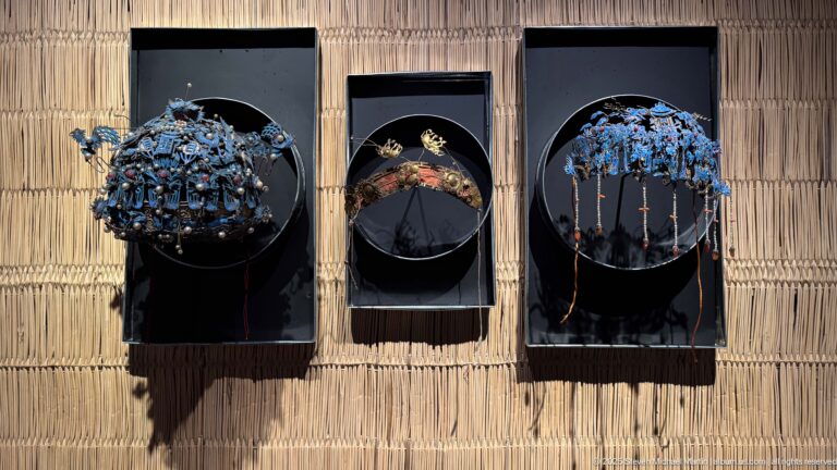 Three framed sets of ornate head or hair ornaments with blue clusters, flowers, and dangling chains.