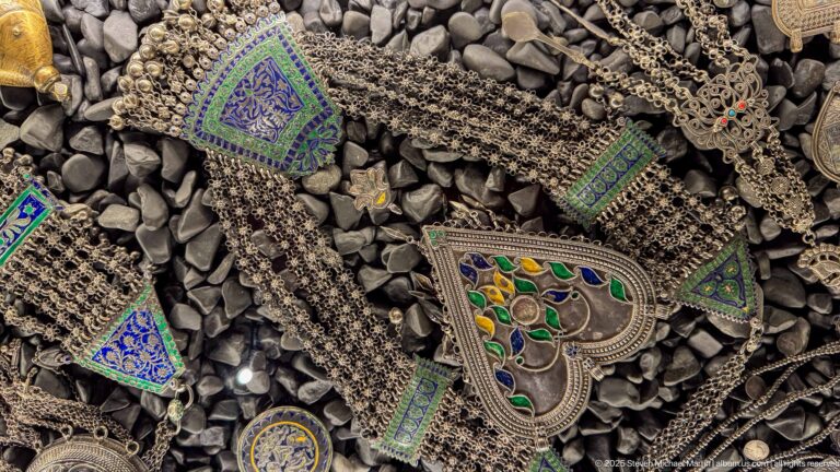 Silver-toned chains with green-and-blue enamelled triangular, rectangular, and heart-shaped pendants.