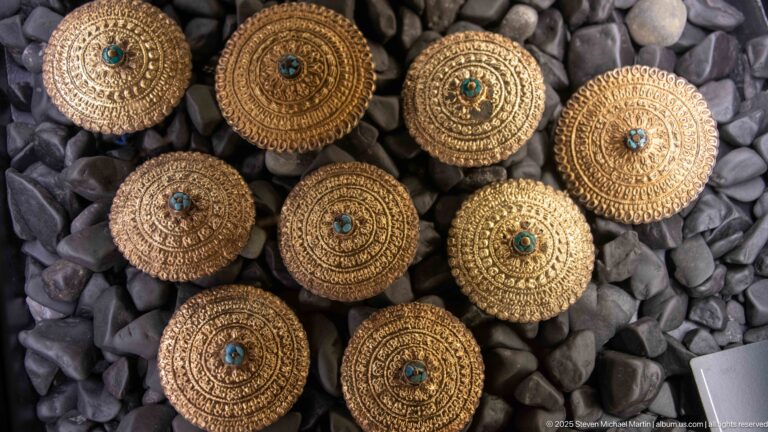 Round gold-toned domed ornaments with concentric filigree wirework and small turquoise-colored centers.