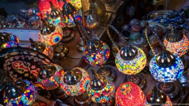 Cluster of glowing mosaic-glass lamps in red, blue, yellow, and green geometric patterns.