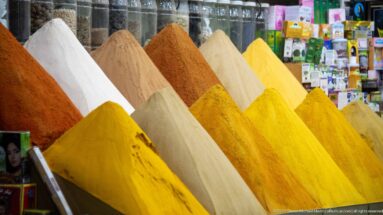 Neat conical mounds of yellow, ochre, white, brown, and red powders at a market stall.