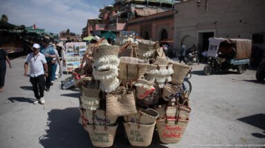 Street cart loaded with many woven baskets and handled containers in the Marrakech market district.