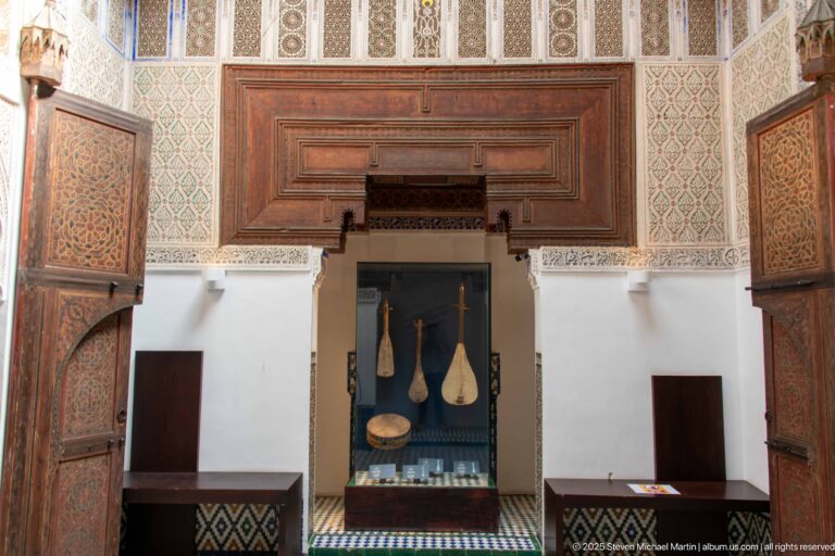 Traditional long-necked instruments displayed in a central niche between open carved wooden doors.