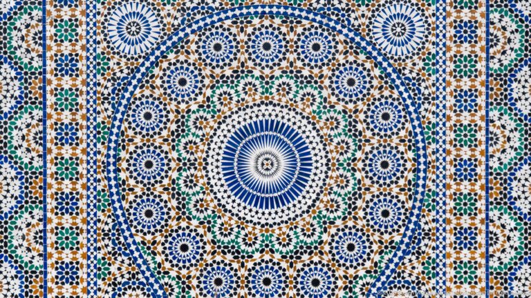 Close-up of a large blue-centered zellij rosette surrounded by dense multicolored geometric mosaic.