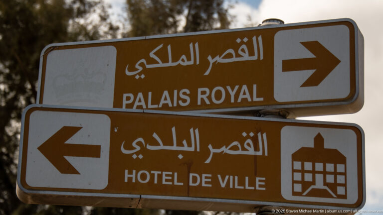 Brown Arabic-French signs point right to Palais Royal and left to Hôtel de Ville.