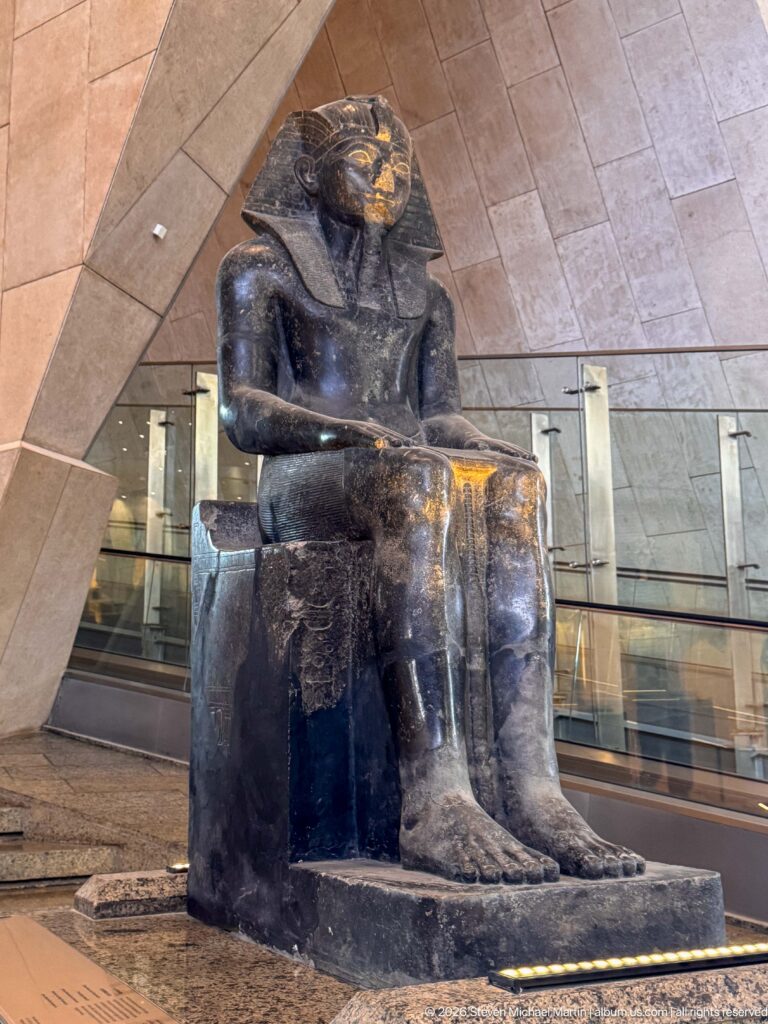 Granite seated statue of the lioness-headed goddess Sekhmet on a cubic throne, displayed on the Grand Staircase.