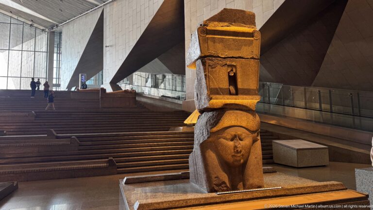 Full view of the Ptolemaic red-granite Hathor capital, with Hathor's face supporting a tall naos above.