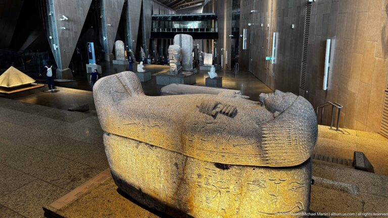 Dynasty 26 granite sarcophagus of Nitocris with her mummiform figure, crossed arms, crook, and flail modeled on the lid.