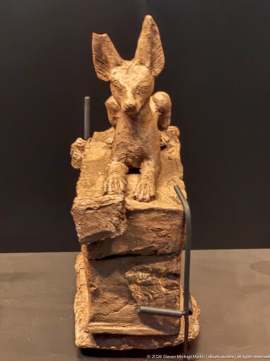 Weathered small animal statuette with oversized upright ears, short muzzle, and squat forelegs on a rough base.