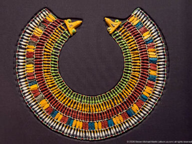 Wide multicolored Egyptian broad collar made of many bead rows with matching falcon-head terminals at both upper ends.