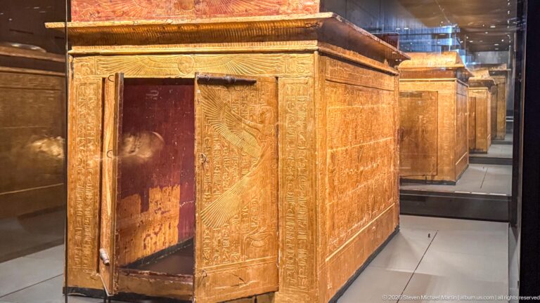 Oblique view of gilded funerary shrine with one open door and another shrine visible behind.