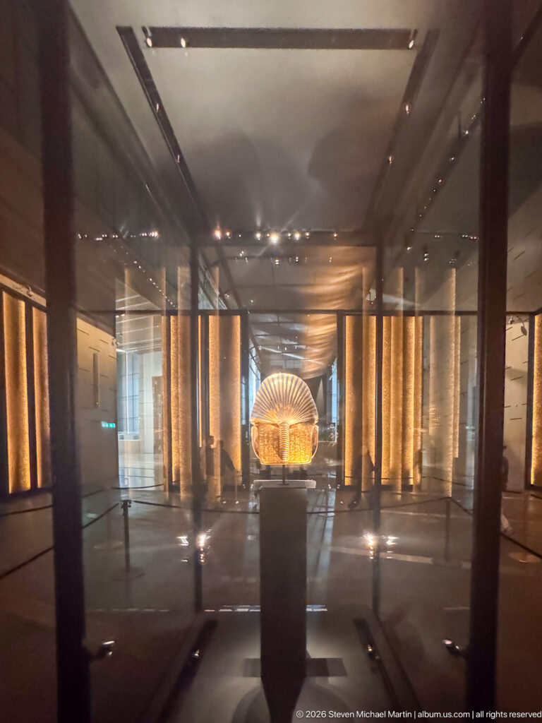Gold palm of Tutankhamun’s Ostrich Hunt Fan displayed on a pedestal, with radiating sockets for the lost feathers.