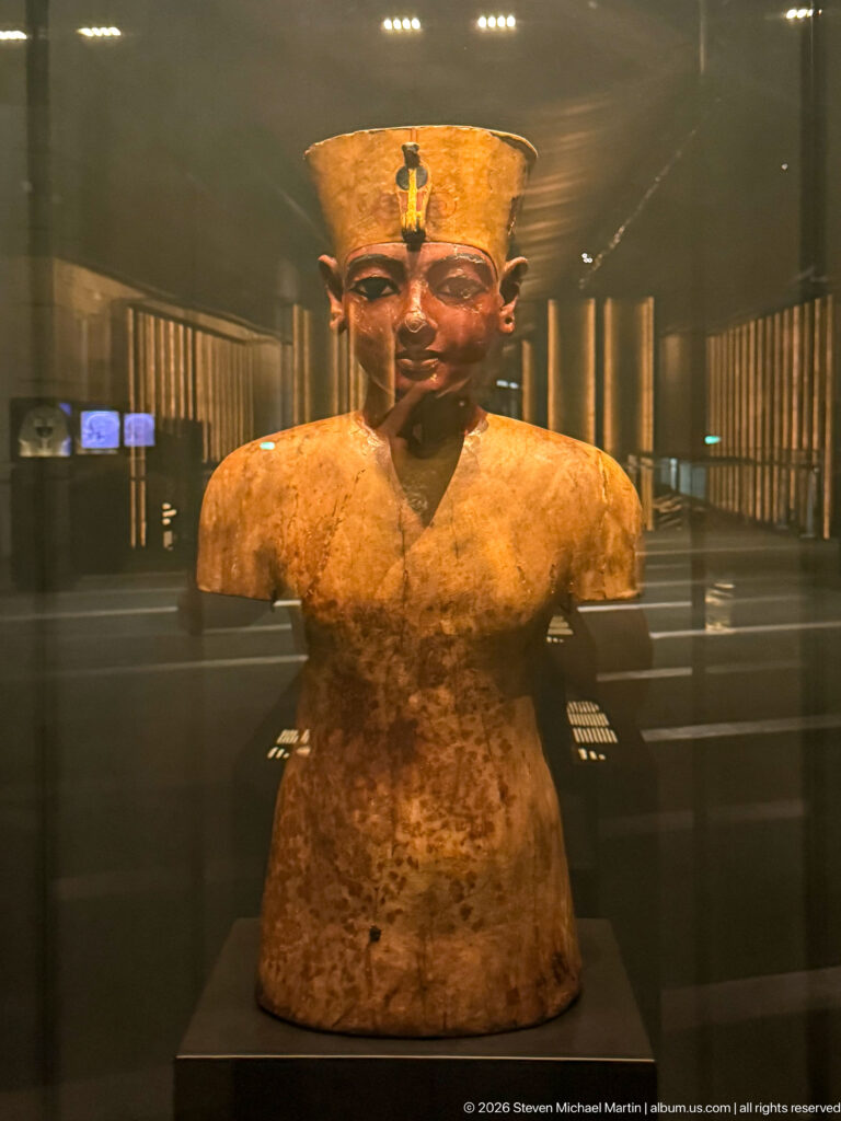 Painted bust of Tutankhamun with idealized face, royal brow emblems, and worn torso.