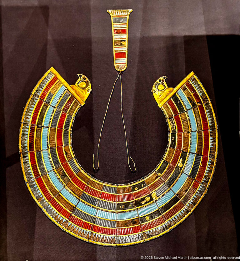 Close frontal view of multicolored broad collar with falcon-head terminals and a rectangular clasp above.