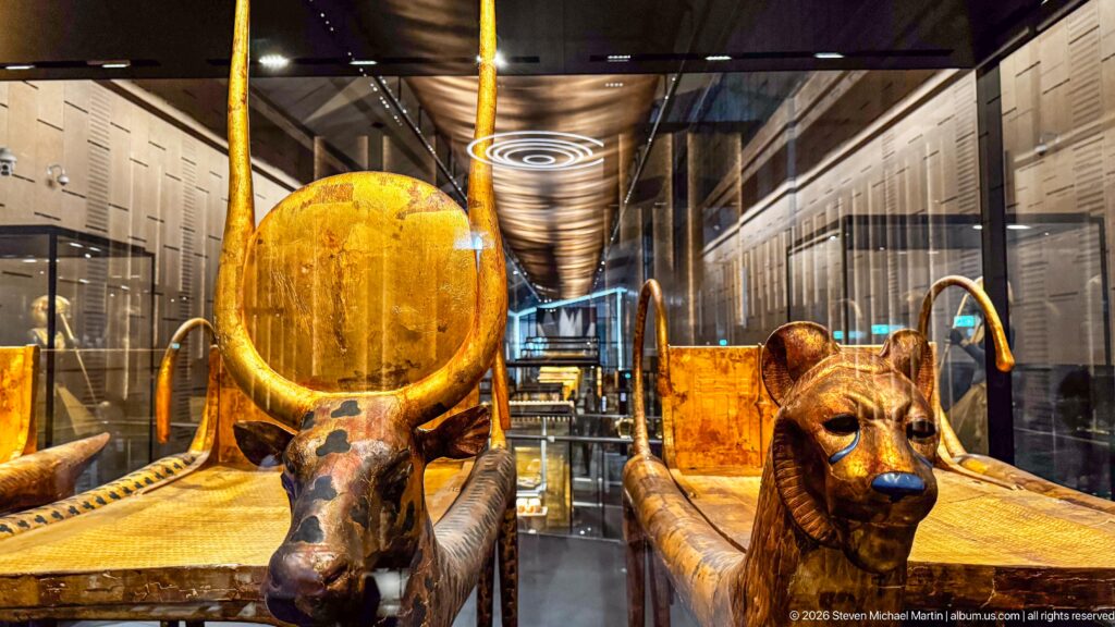 Two animal-headed funerary couches displayed side by side, one bovine and one feline-like.