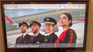 Royal Jordanian airport screen showing four uniformed crew members in front of an aircraft with “Welcome Aboard” text.