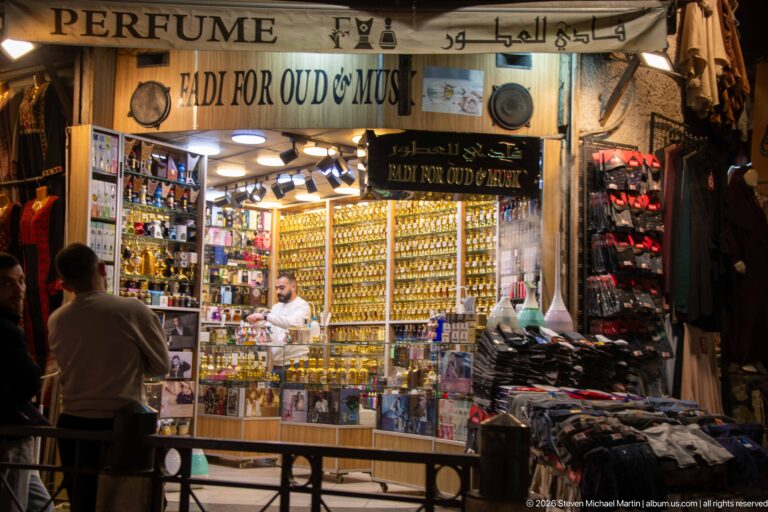 Bright music shop with rows of ouds displayed behind the counter and bilingual signage above the entrance.