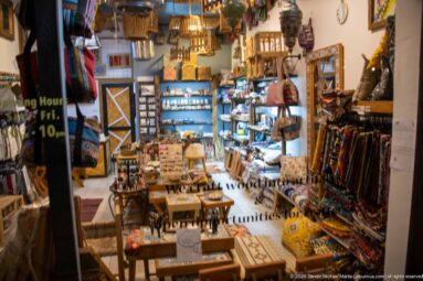 Small Amman craft shop filled with wooden objects, textiles, jewelry, and souvenir displays.