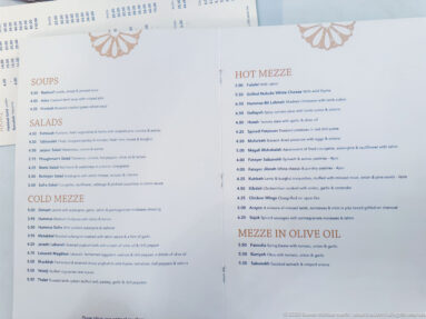 Open restaurant menu with sections for soups, salads, hot mezze, cold mezze, and mezze in olive oil.