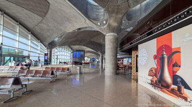 Jordan-themed wall graphic beside airport seating under concrete roof modules at Queen Alia International Airport.