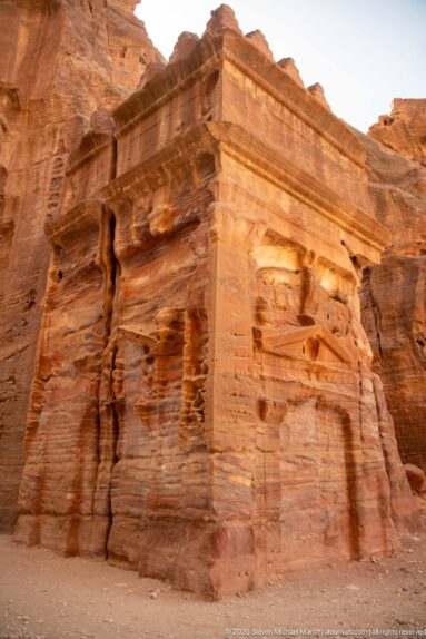 Projecting sandstone architectural corner with broad cornice and deeply weathered vertical rock surfaces at Petra.