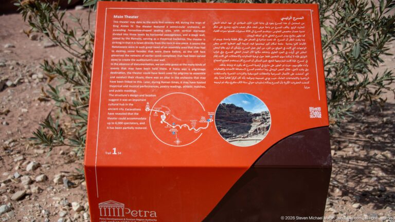 Red bilingual interpretive panel for Petra Theater with text, diagram, and inset site photograph.