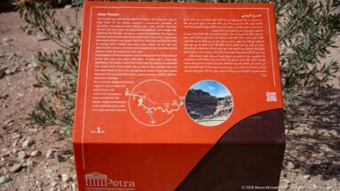 Red bilingual interpretive panel for Petra Theater with text, diagram, and inset site photograph.