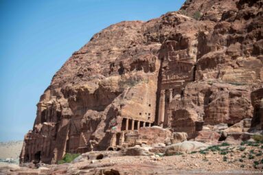 Wide view of Petra’s Palace Tomb carved into Jabal al-Khubtha, with its broad multi-story façade and surrounding cliff.