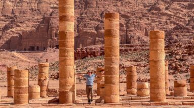 Visitor among tall re-erected columns and excavated remains of Petra’s Great Temple complex.