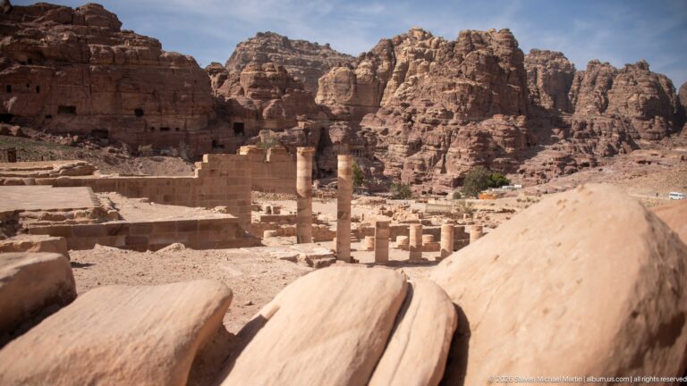 Standing columns, fallen stone blocks, and excavated walls in the lower precinct of Petra’s Great Temple.
